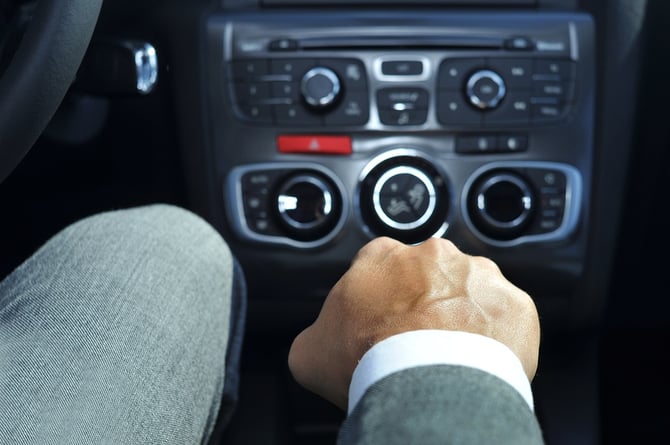 closeup of a young man in suit driving a car with manual transmi