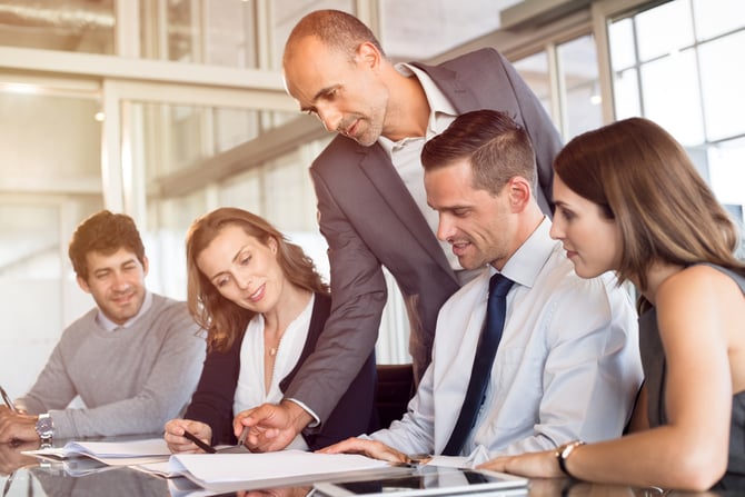bigstock-Team-leader-pointing-at-report-223320193