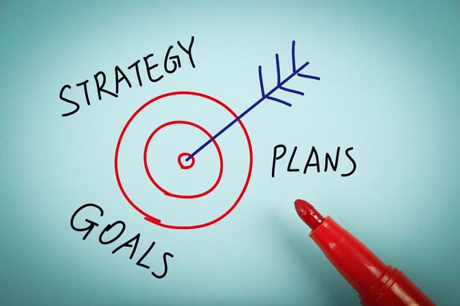 Hand-drawn red target with a blue arrow in the bullseye, framed by the words strategy, goals, and plans, illustrating a small business owner choosing one growth strategy to commit to.