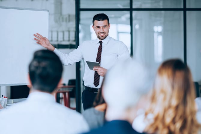 a professional in a tie leads a leadership training program