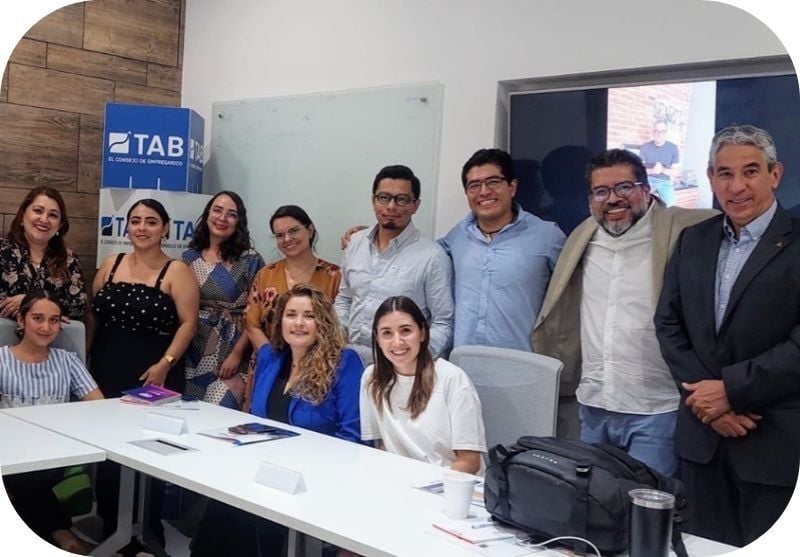 a group of diverse business owners pose around a board table